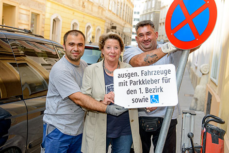 Stenzel und zwei Bauarbeiter mit dem neuen Verkehrsschild plus Hinweistafel