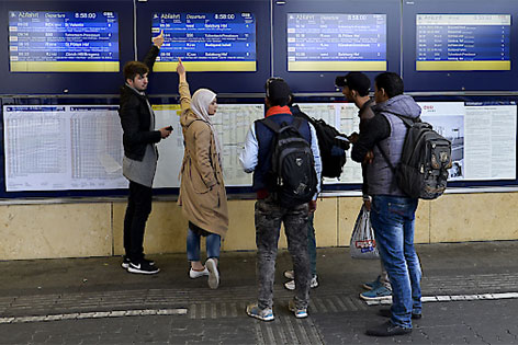 Flüchtlinge vor einer Zuganzeigetafel
